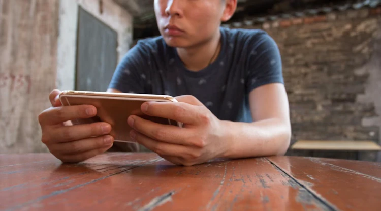 Person playing a mobile esports game on a smartphone in landscape mode